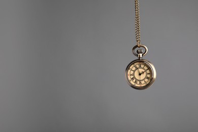 Stylish pendulum on grey background, space for text. Hypnotherapy session