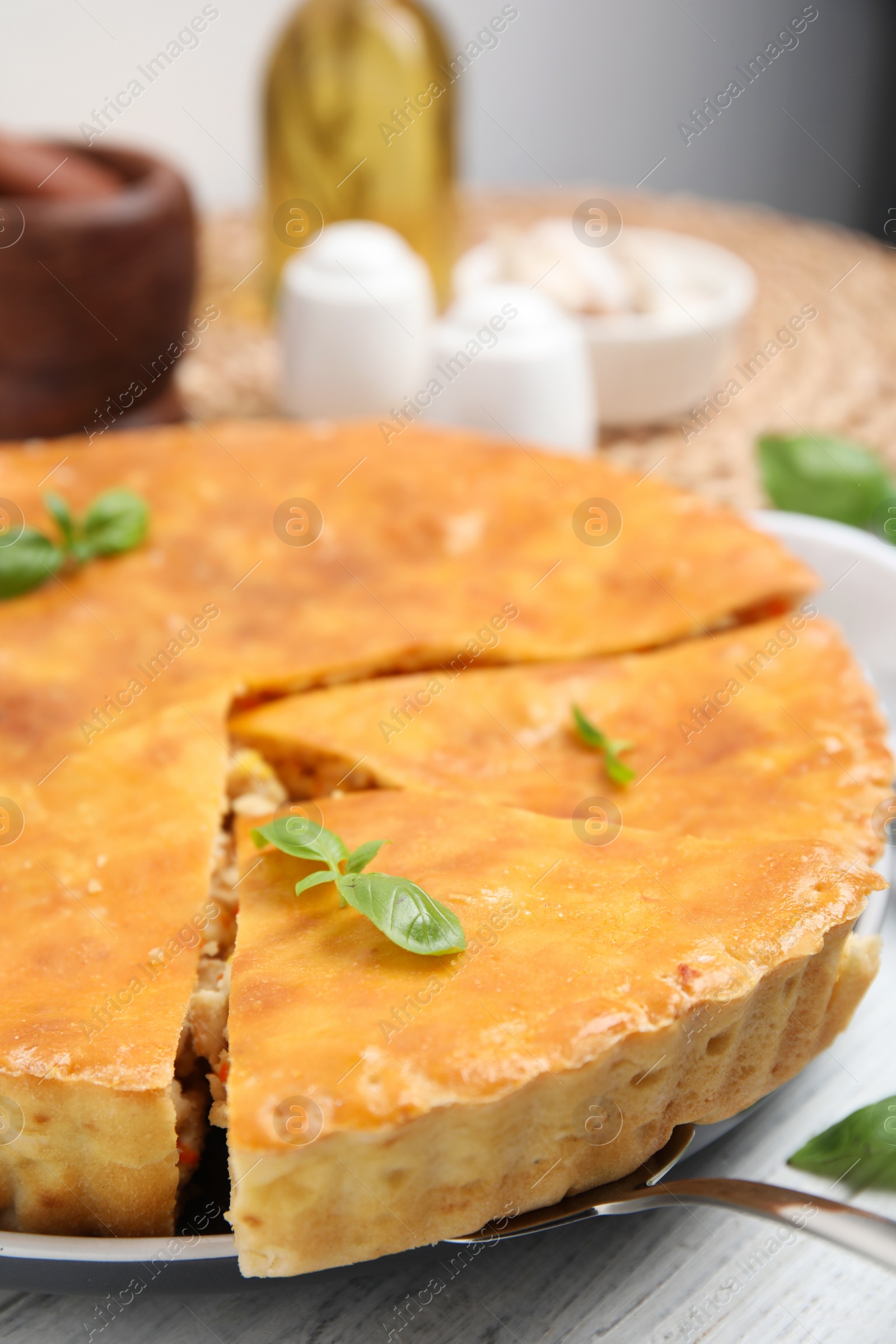 Photo of Delicious meat pie with basil on white table, closeup
