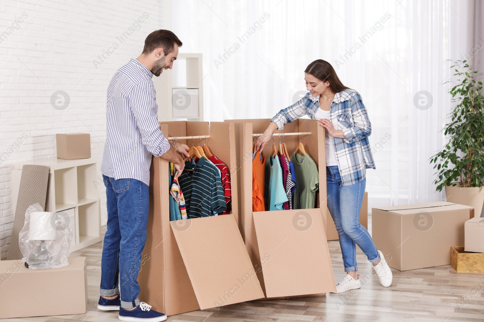 Photo of Young couple near wardrobe boxes at home