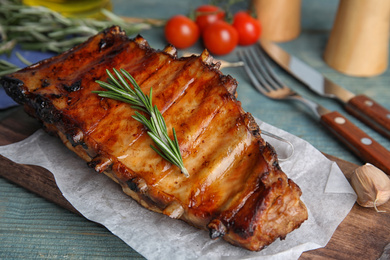 Photo of Tasty grilled ribs with rosemary on table