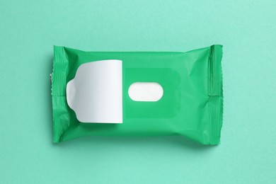 Photo of Wet wipes flow pack on turquoise background, top view