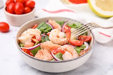 Delicious pomelo salad with shrimps served on white marble table, closeup