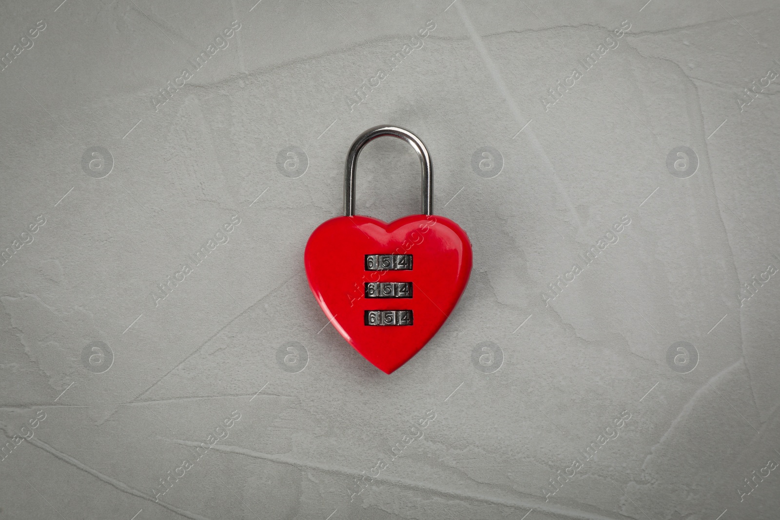 Photo of Red heart shaped combination lock on light grey table, top view