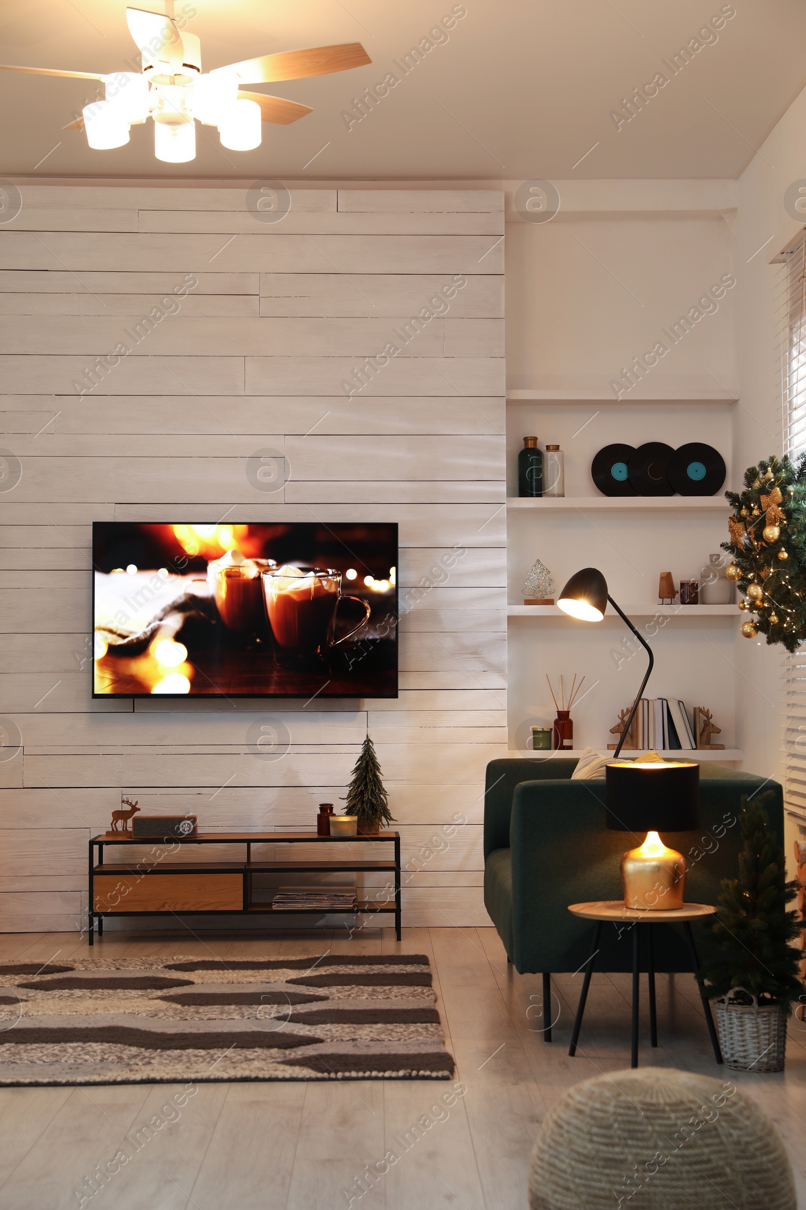 Photo of Plasma TV on white wooden wall in living room beautifully decorated for Christmas