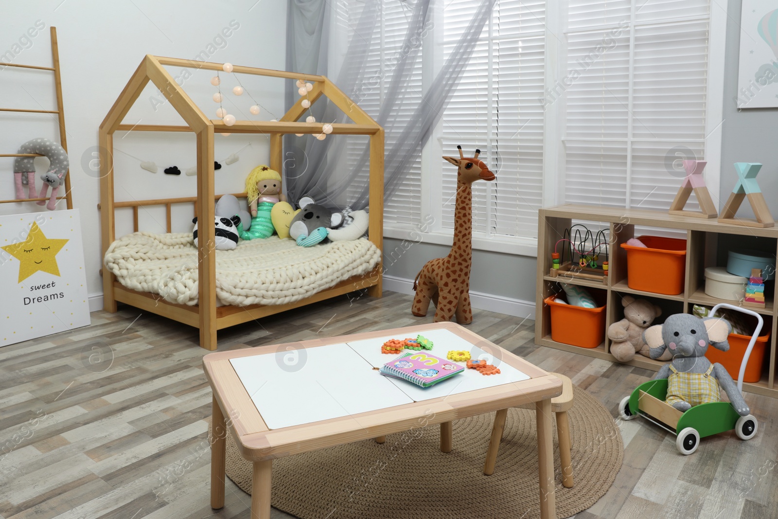 Photo of Cute child's room interior with toys and wooden furniture