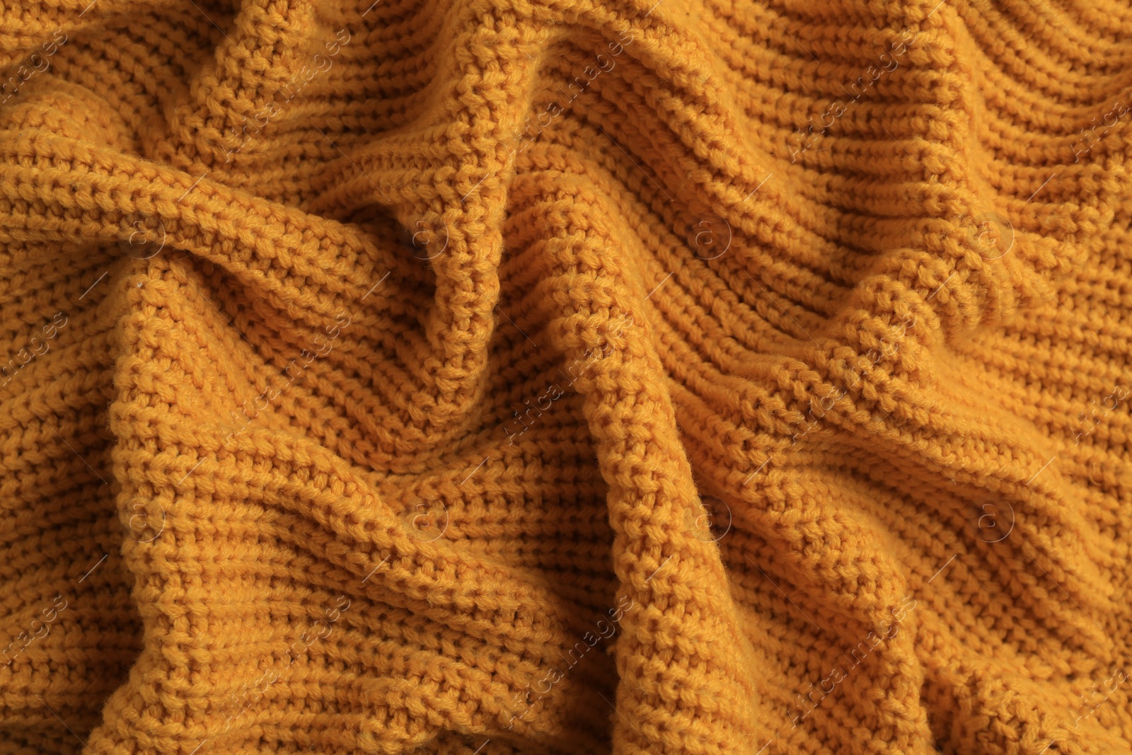 Photo of Beautiful orange knitted fabric as background, top view