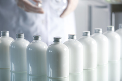 Photo of Many bottles with cosmetic product in laboratory