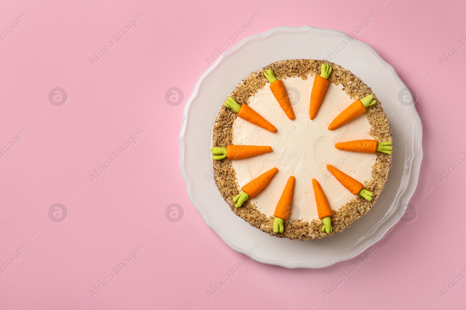 Photo of Dish with tasty carrot cake on pink background, top view. Space for text