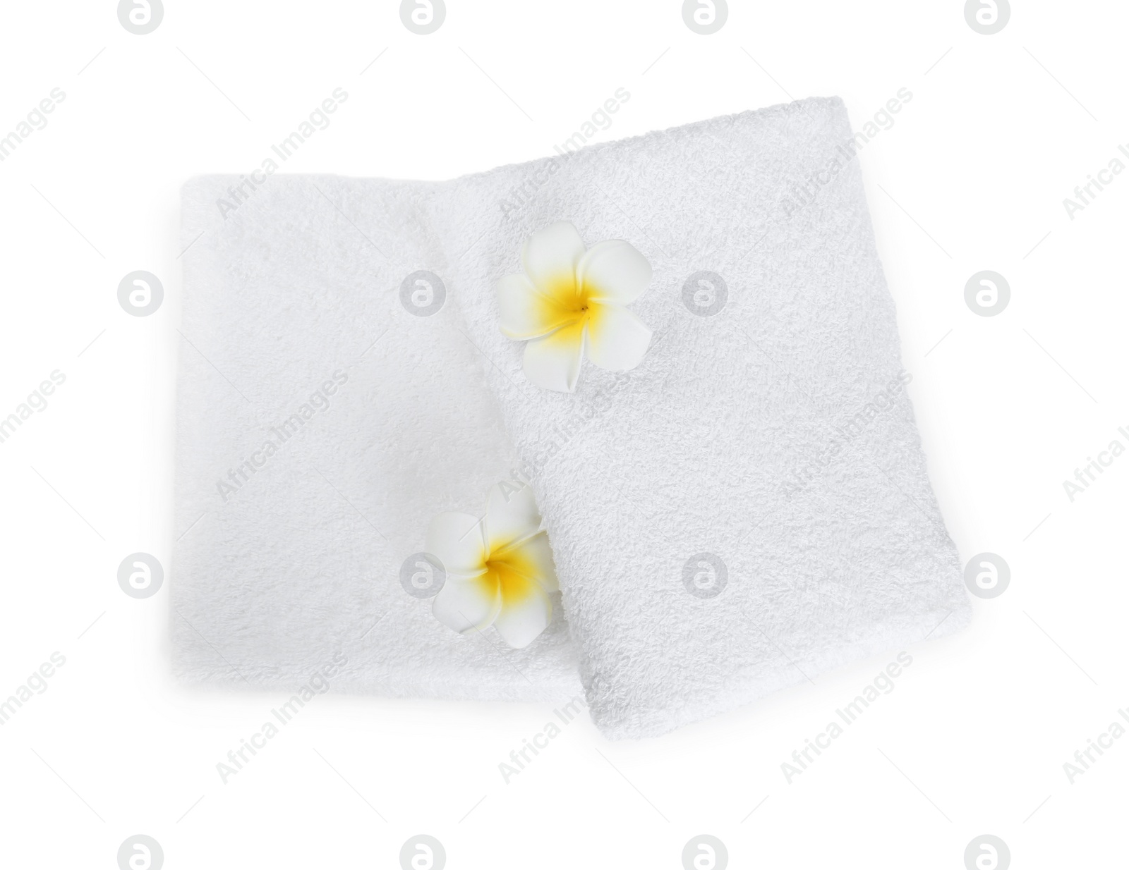 Photo of Terry towels and plumeria flowers isolated on white, top view