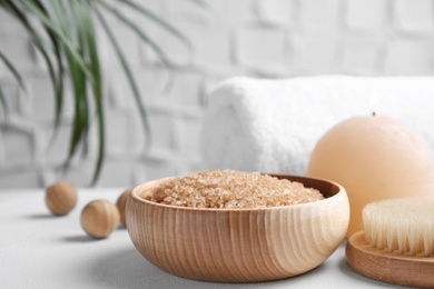 Photo of Salt for spa scrubbing procedure in wooden bowl on white table