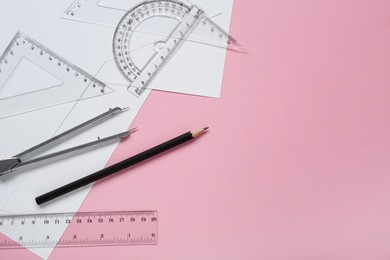 Photo of Different rulers, pencils and compass on pink background, flat lay. Space for text