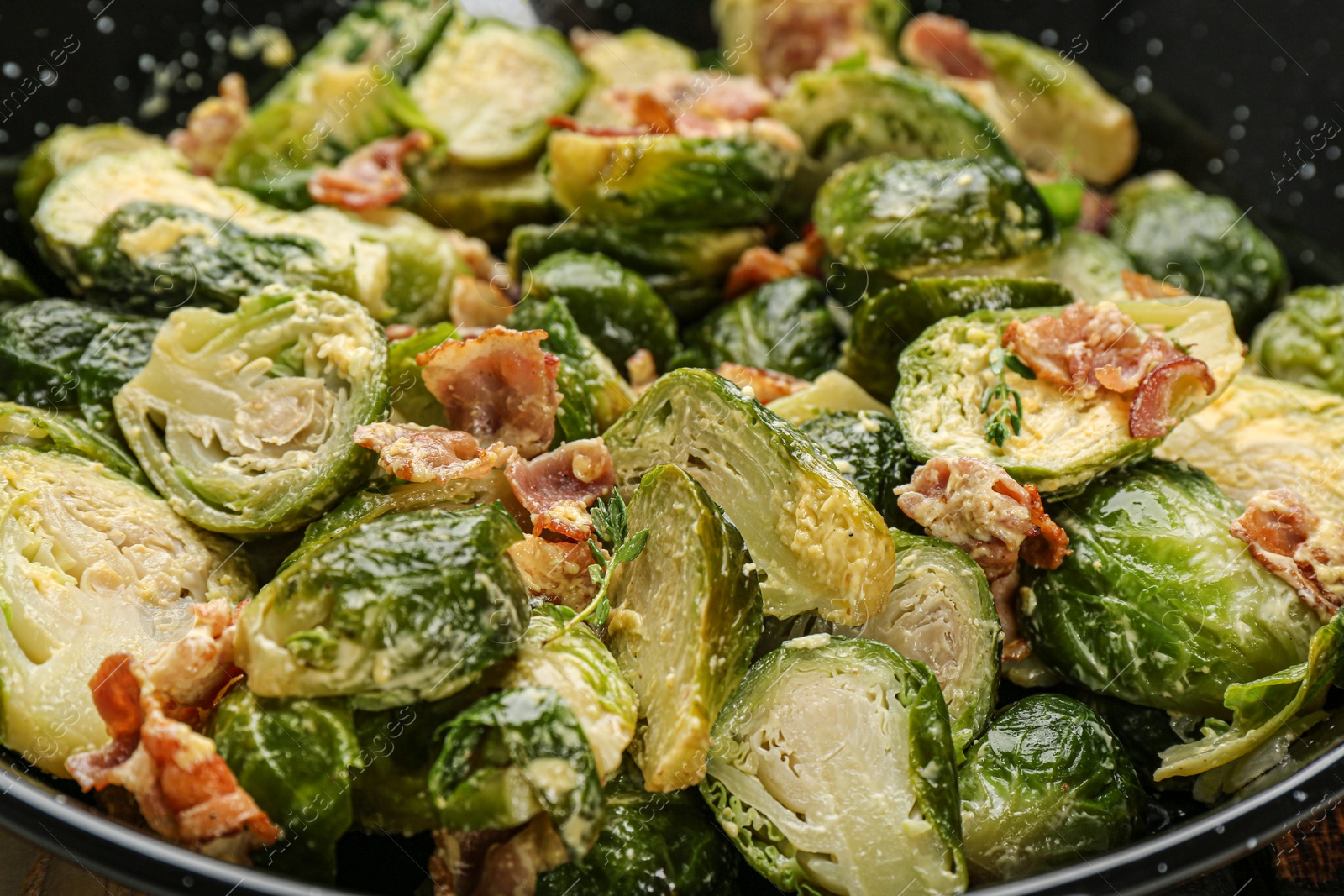 Photo of Delicious cooked Brussels sprouts with bacon in pan, closeup