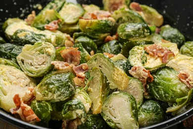 Delicious cooked Brussels sprouts with bacon in pan, closeup