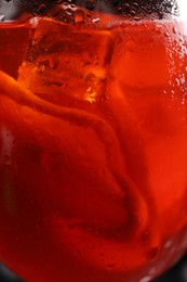 Photo of Tasty Aperol spritz cocktail with ice cubes in glass, closeup