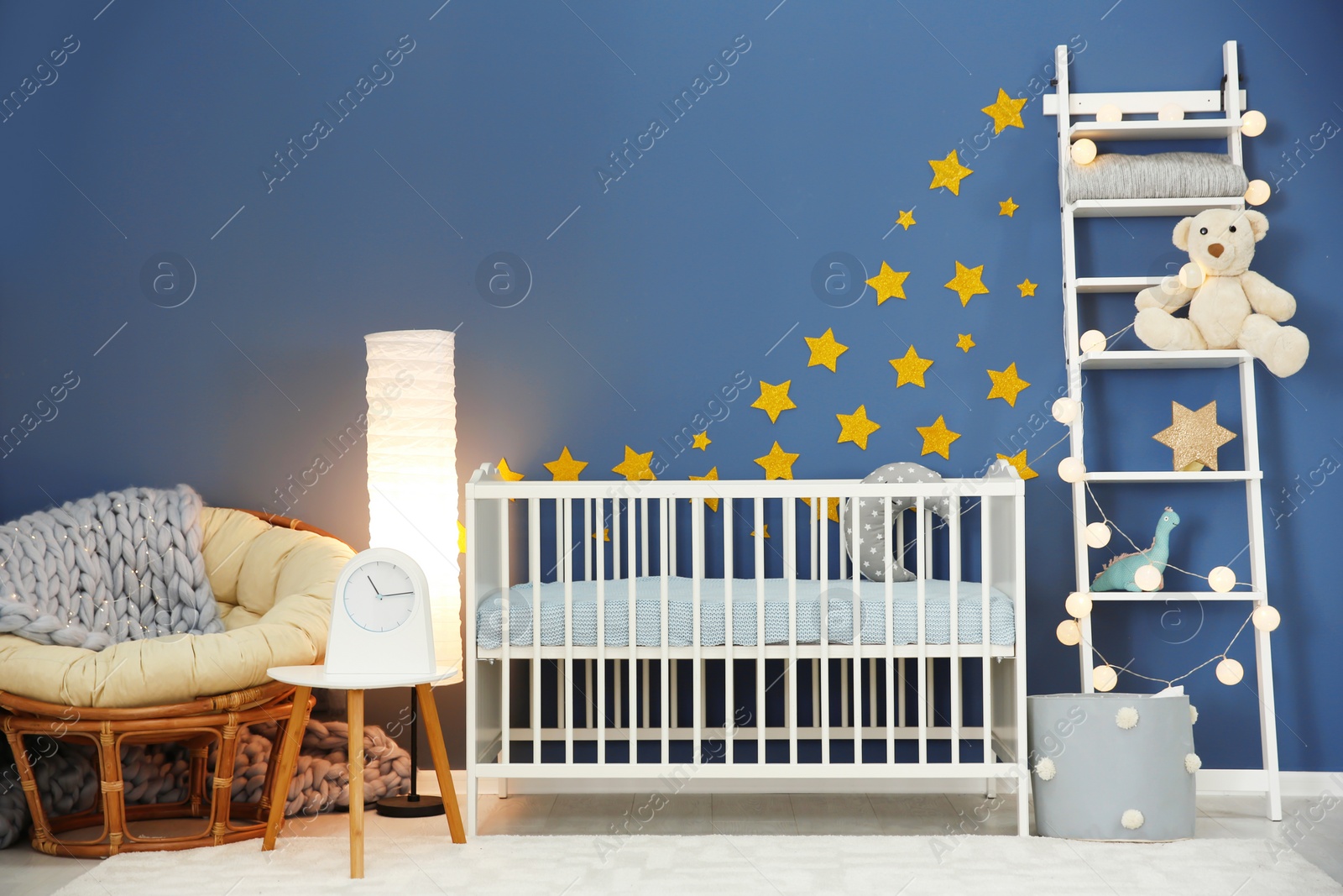 Photo of Baby room interior with comfortable crib and papasan chair