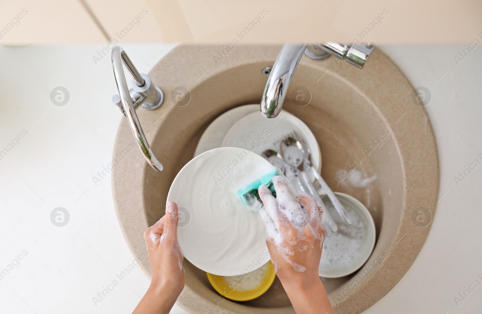 Photo of Woman washing dirty dishes in kitchen sink, top view. Cleaning chores