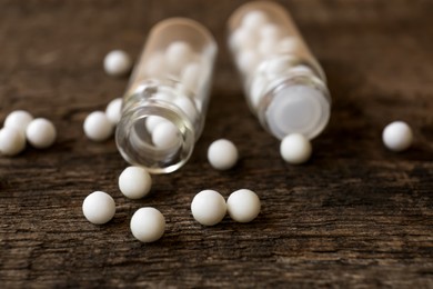 Photo of Bottles of homeopathic remedy on the wooden table, closeup