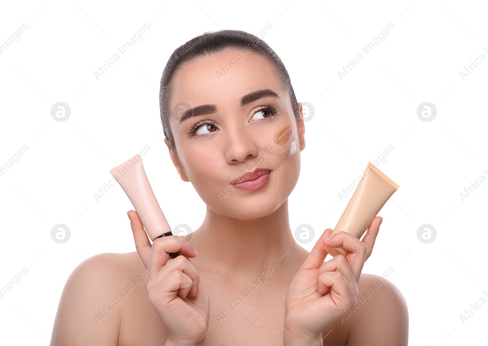 Photo of Woman holding tubes of foundation on white background