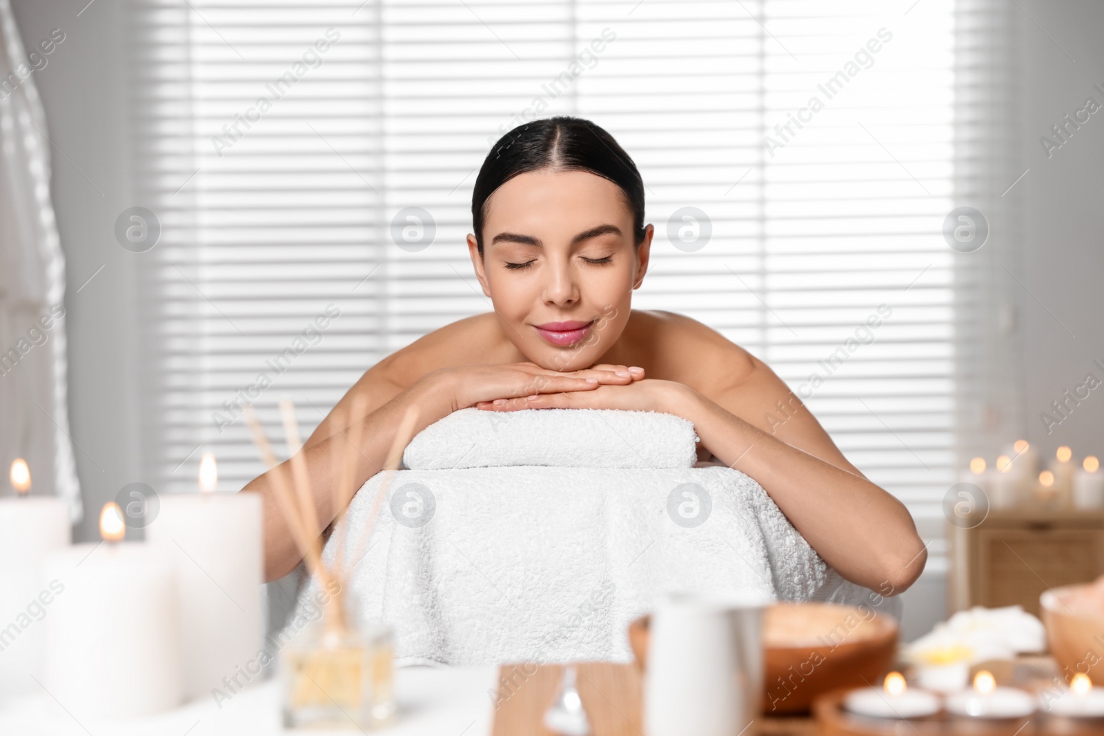 Photo of Beautiful woman relaxing on massage table in spa salon