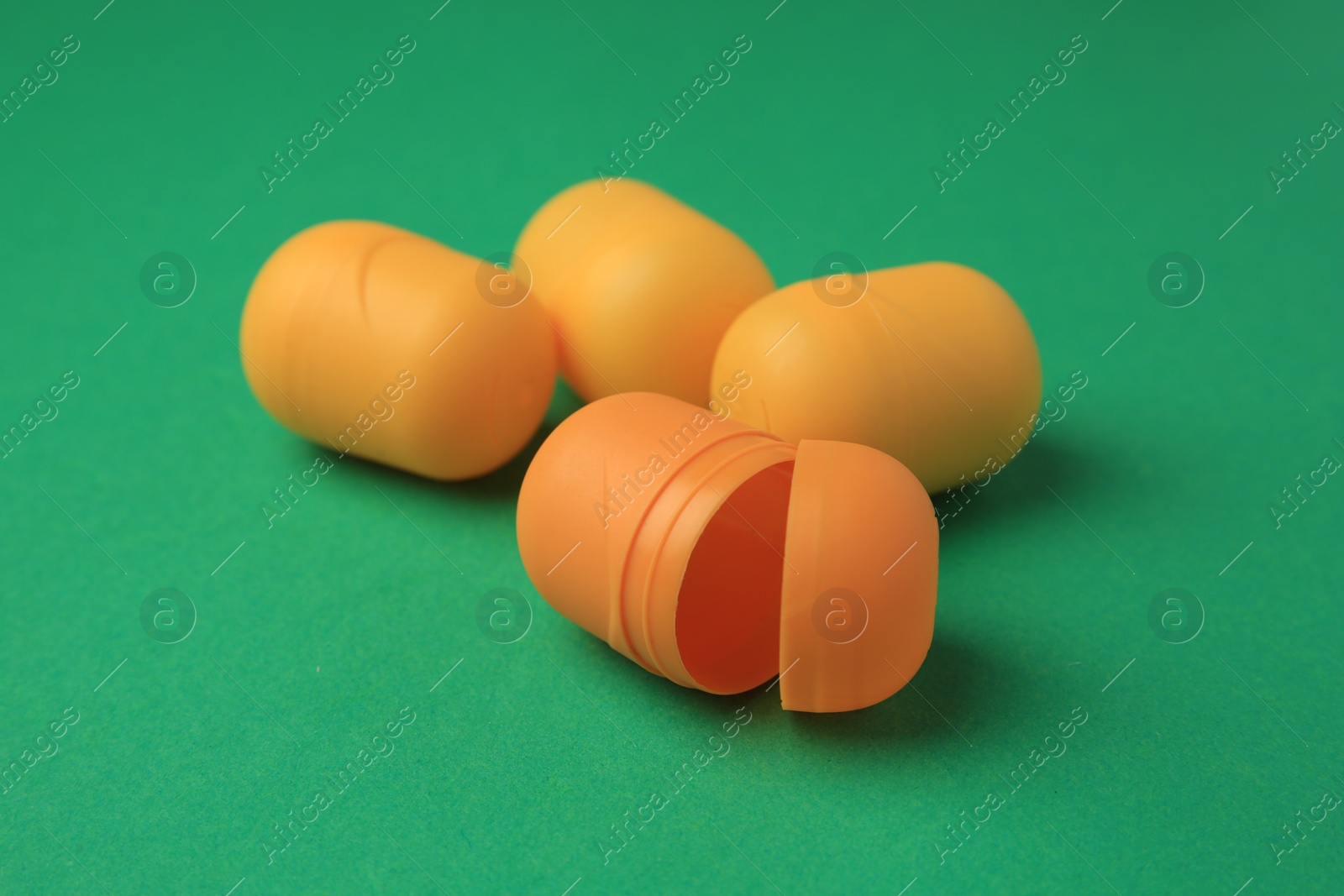 Photo of Sveti Vlas, Bulgaria - June 29, 2023: Plastic capsules from Kinder Surprise Eggs on green background