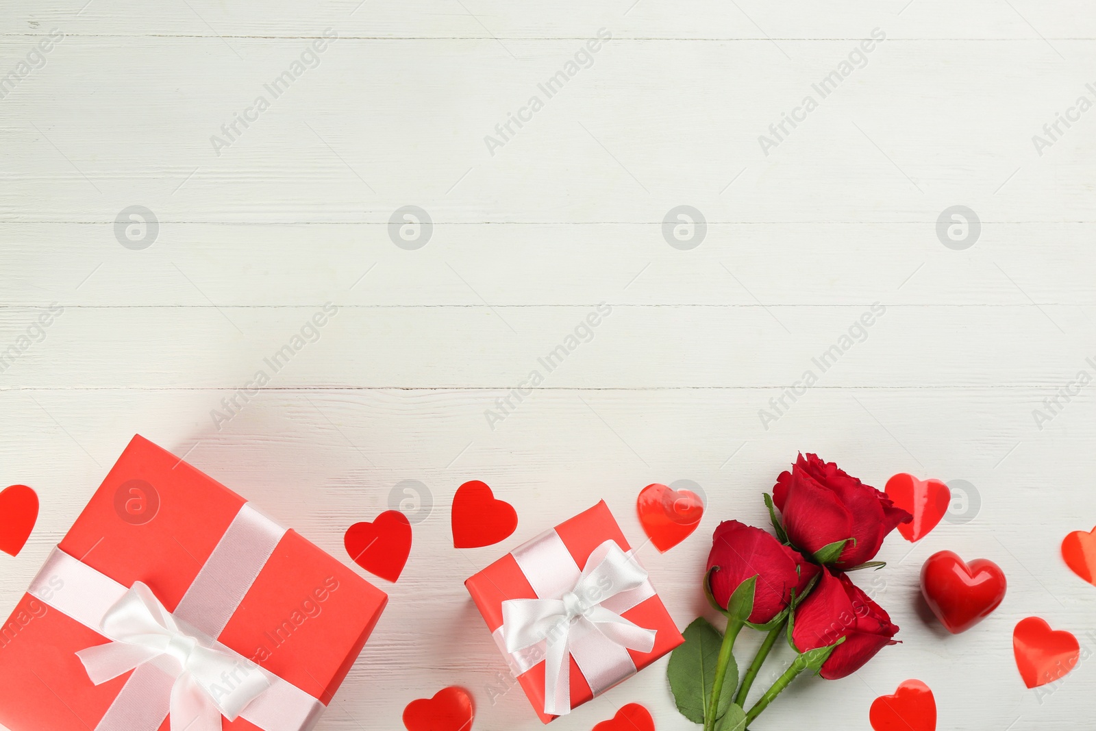 Photo of Gift boxes, roses and hearts on white wooden background, flat lay with space for text. Valentine's Day celebration