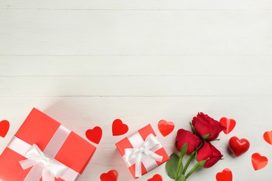 Photo of Gift boxes, roses and hearts on white wooden background, flat lay with space for text. Valentine's Day celebration