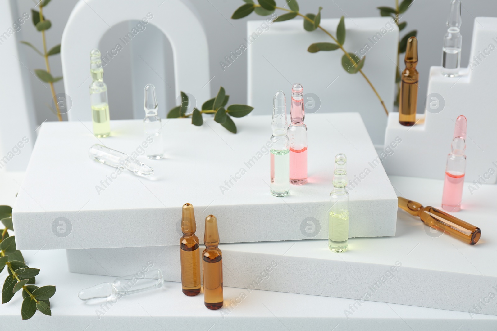 Photo of Stylish presentation of different skincare ampoules on white background