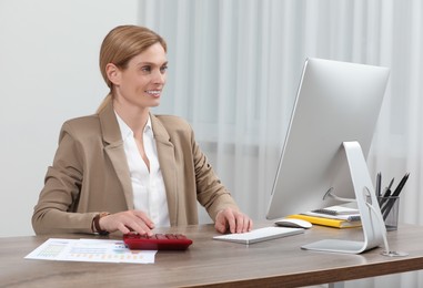 Professional accountant working at wooden desk in office