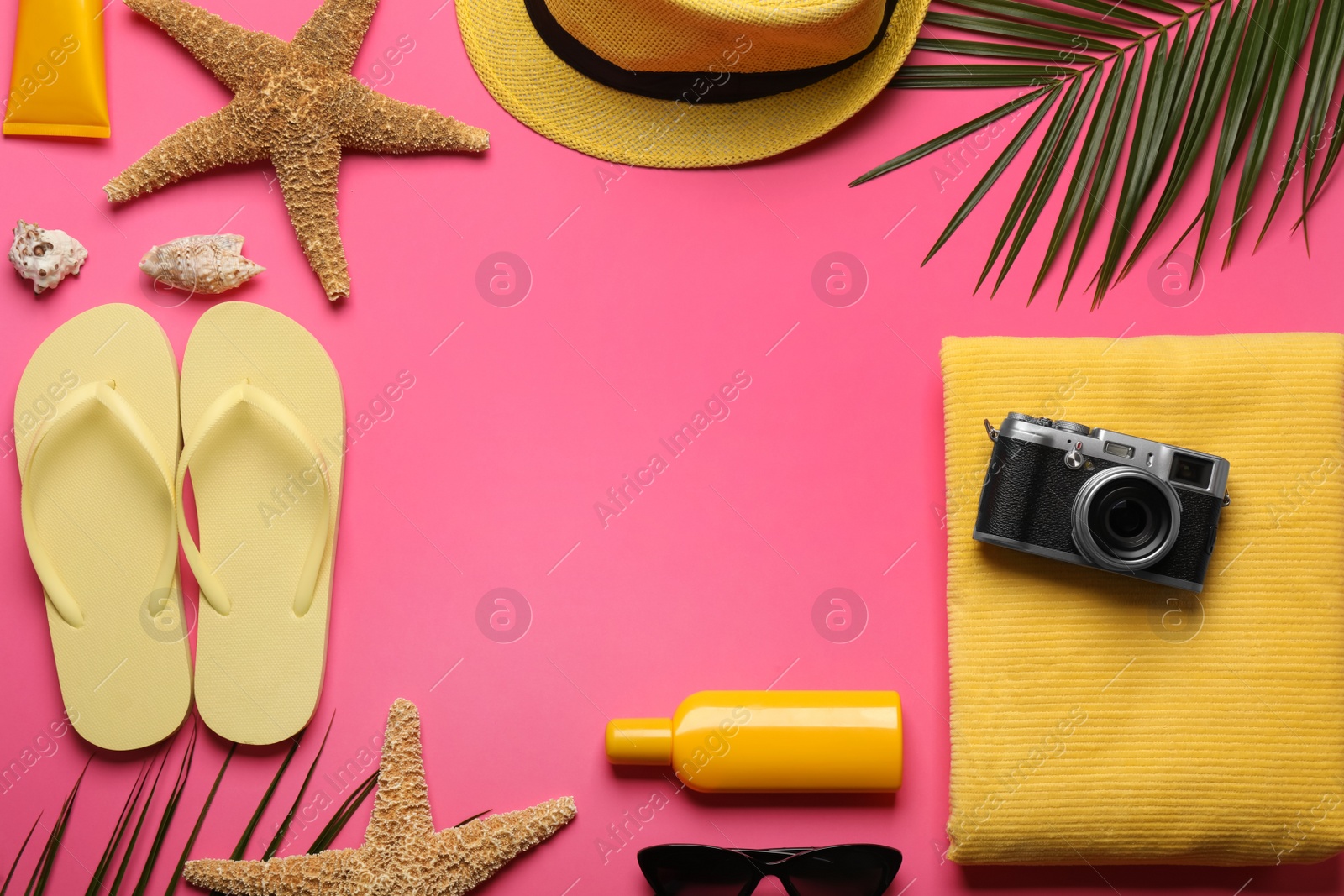 Photo of Frame of different beach objects on pink background, flat lay. Space for text