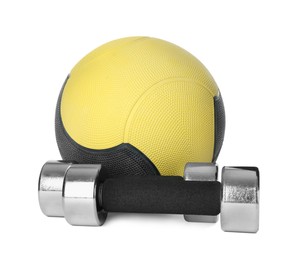 Medicine ball and dumbbells on white background