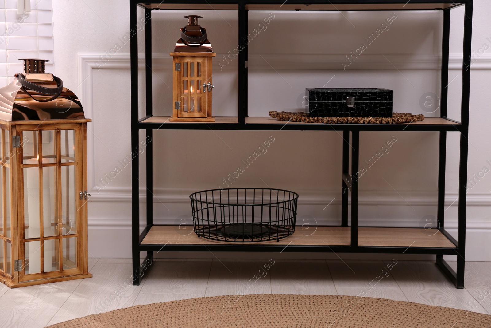 Photo of Stylish shelving unit with different decor near white wall indoors. Interior design