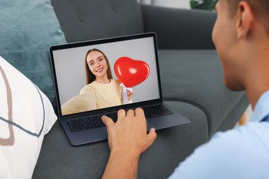 Image of Long distance love. Man having video chat with his girlfriend via laptop at home, closeup