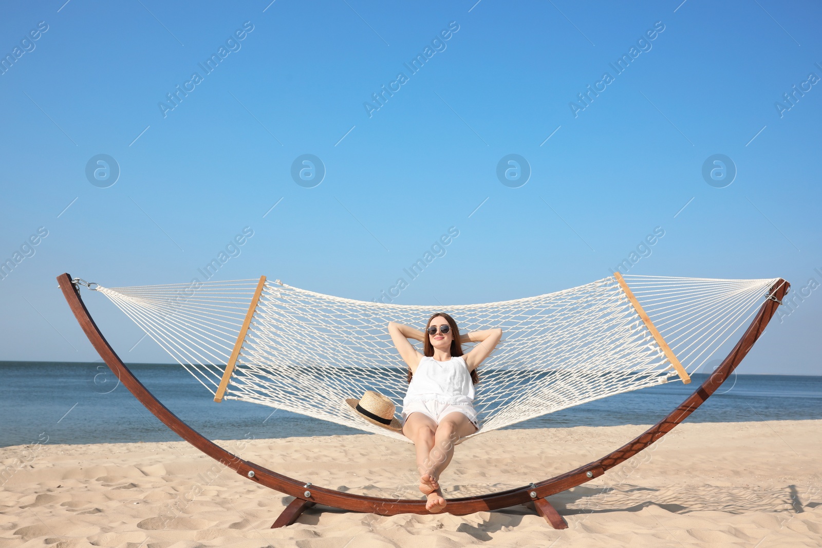 Photo of Young woman relaxing in hammock on beach