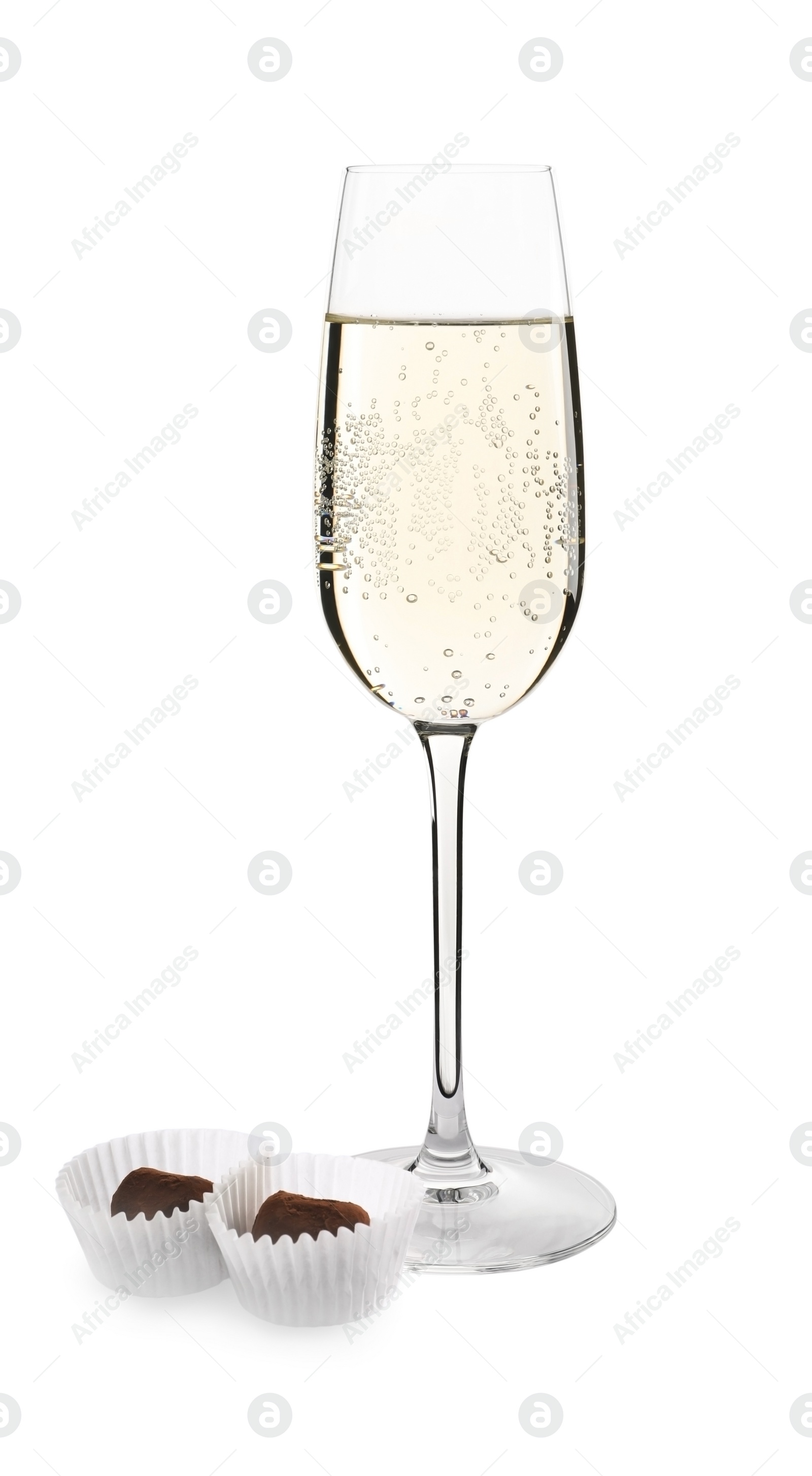 Photo of Glass of delicious sparkling wine and chocolate truffles isolated on white