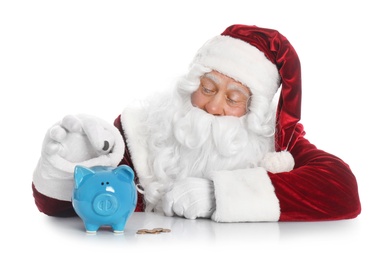Photo of Santa Claus putting coin into piggy bank on white background