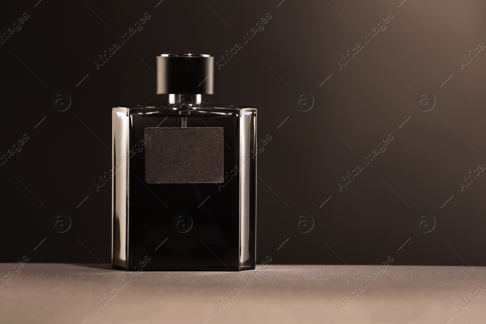 Photo of Luxury men`s perfume in bottle on grey table, space for text