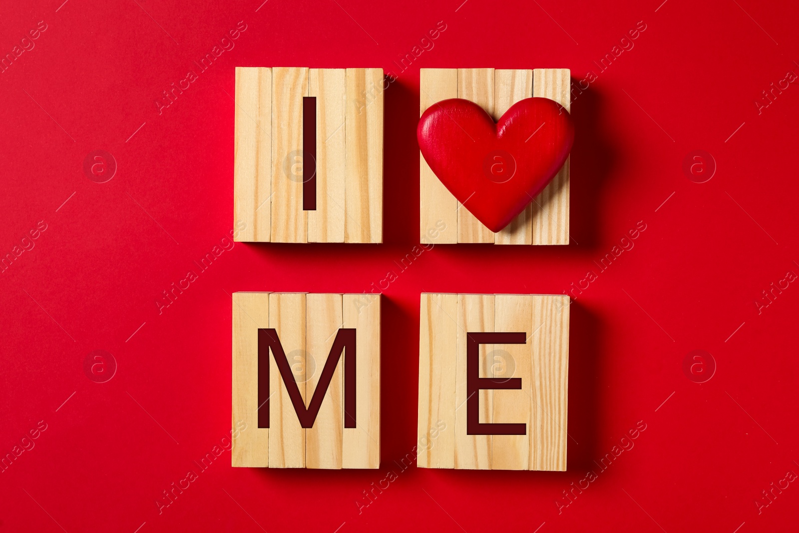 Photo of Phrase I Love Me made with wooden cubes and heart on red background, flat lay