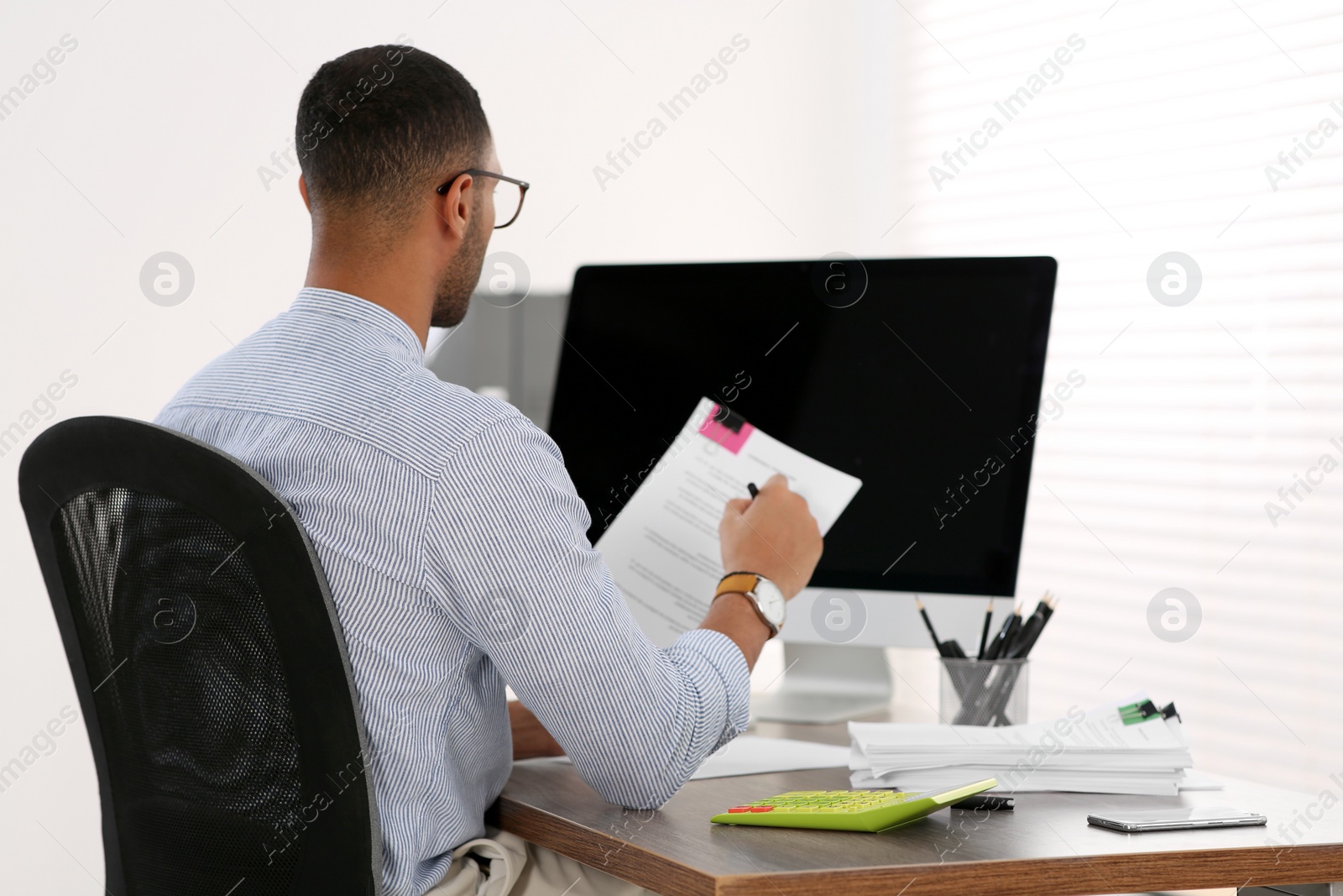 Photo of Businessman working with documents at wooden table in office