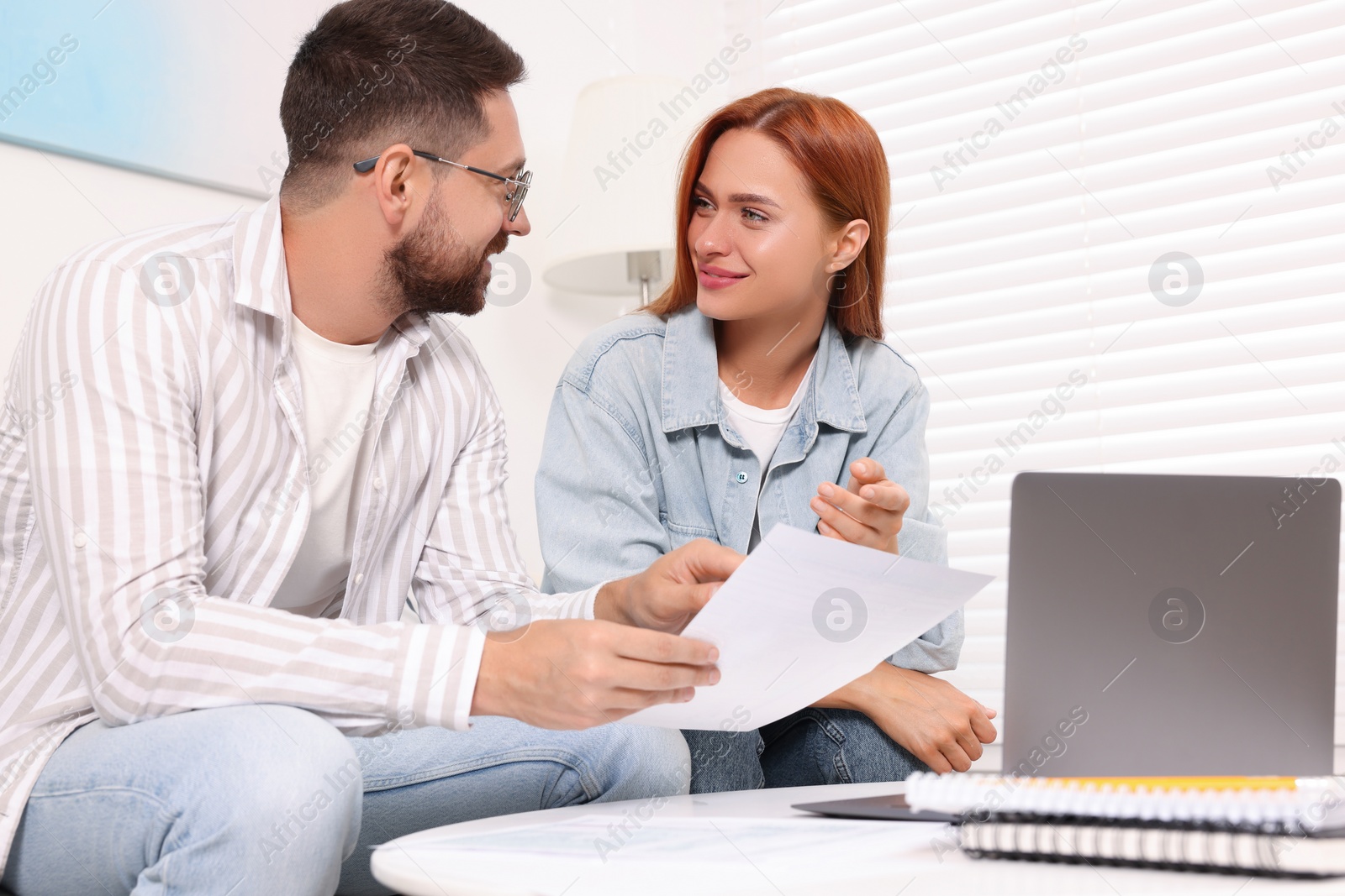 Photo of Couple doing taxes at table in living room