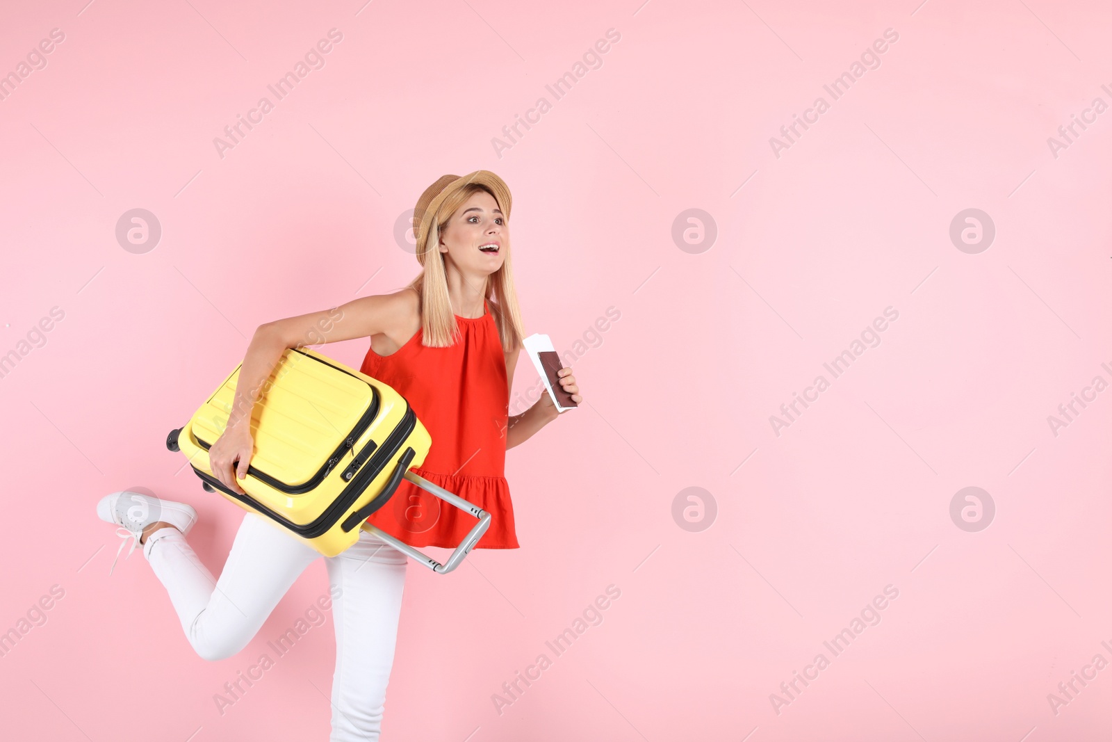 Photo of Woman with suitcase and passport running on color background. Space for text