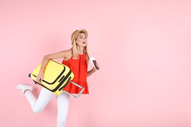 Photo of Woman with suitcase and passport running on color background. Space for text