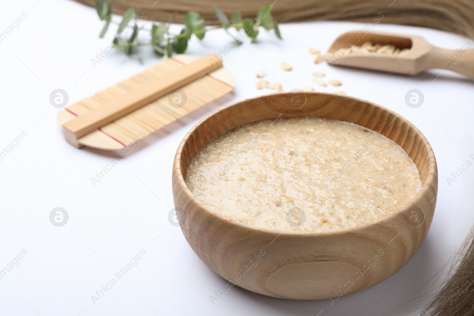 Photo of Homemade hair mask, oatmeal and comb on white background