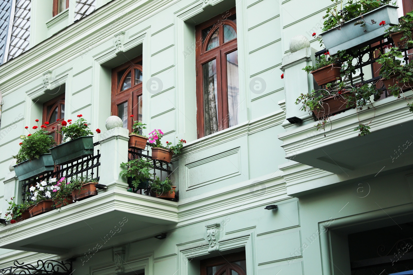 Photo of Exterior of beautiful residential building with flowers on balconies