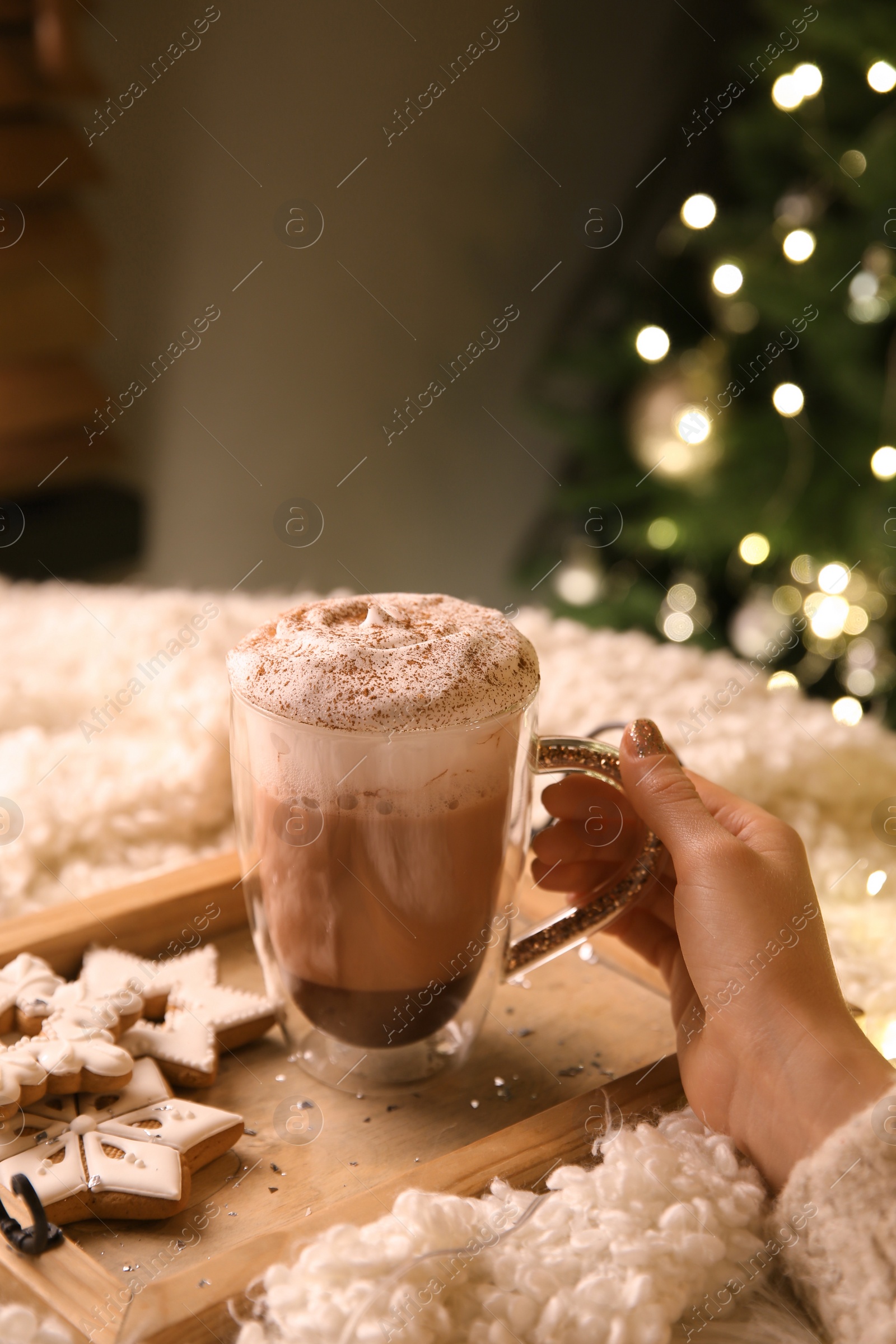 Photo of Woman with cup of hot drink and Christmas cookies at home, closeup