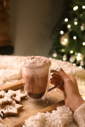 Photo of Woman with cuphot drink and Christmas cookies at home, closeup