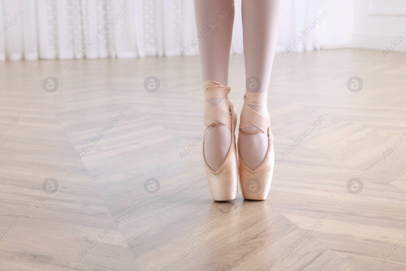 Photo of Little ballerina practicing dance moves in studio, closeup of legs. Space for text