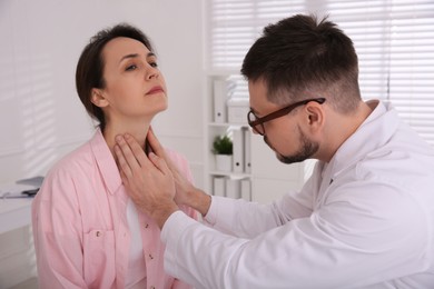 Photo of Doctor examining thyroid gland of patient in hospital