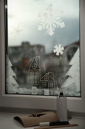 Photo of Beautiful drawing made with artificial snow on window at home. Christmas decor
