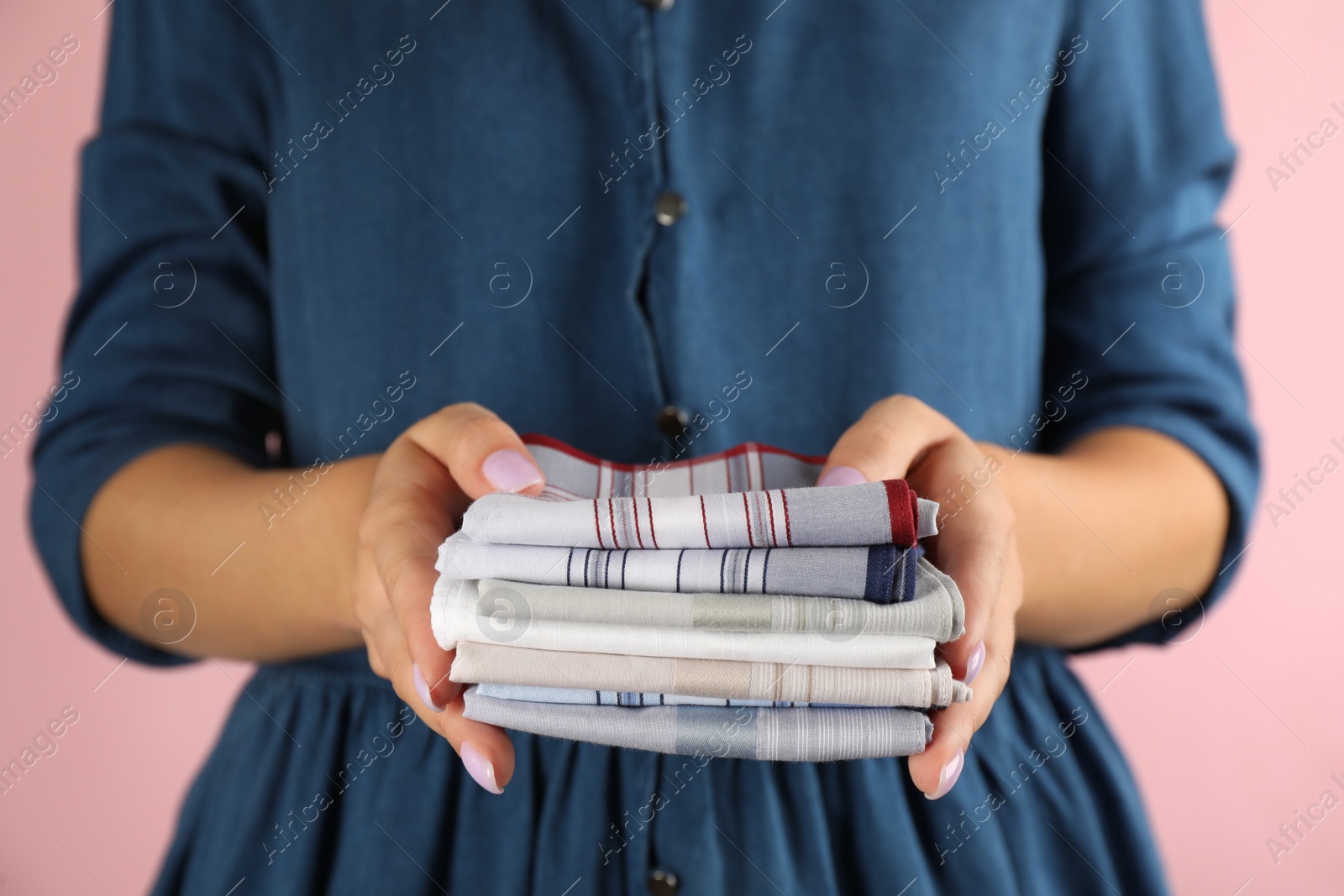 Photo of Woman holding many different handkerchiefs against pink background, closeup