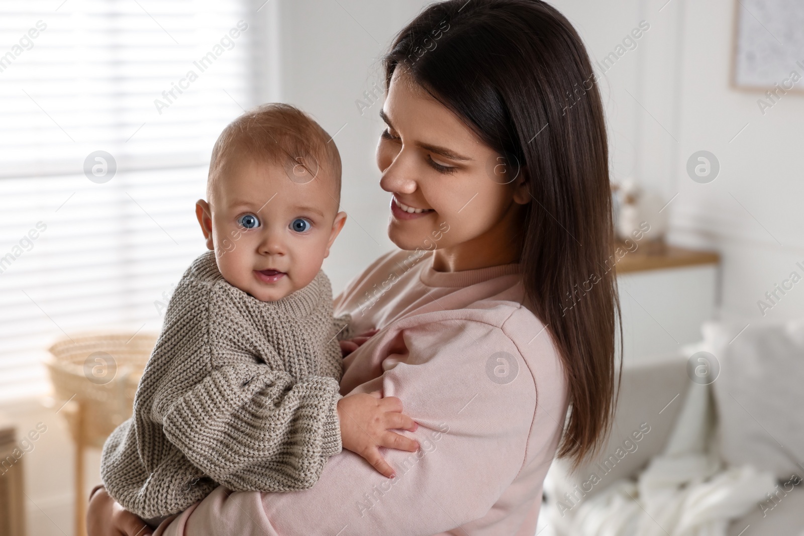 Photo of Happy young mother with her baby at home